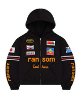 Bravest Studios Ransom Zip Up Hoodie black, moto-racing zip hoodie with embroidered sponsor patches and orange ransom lettering, front view
