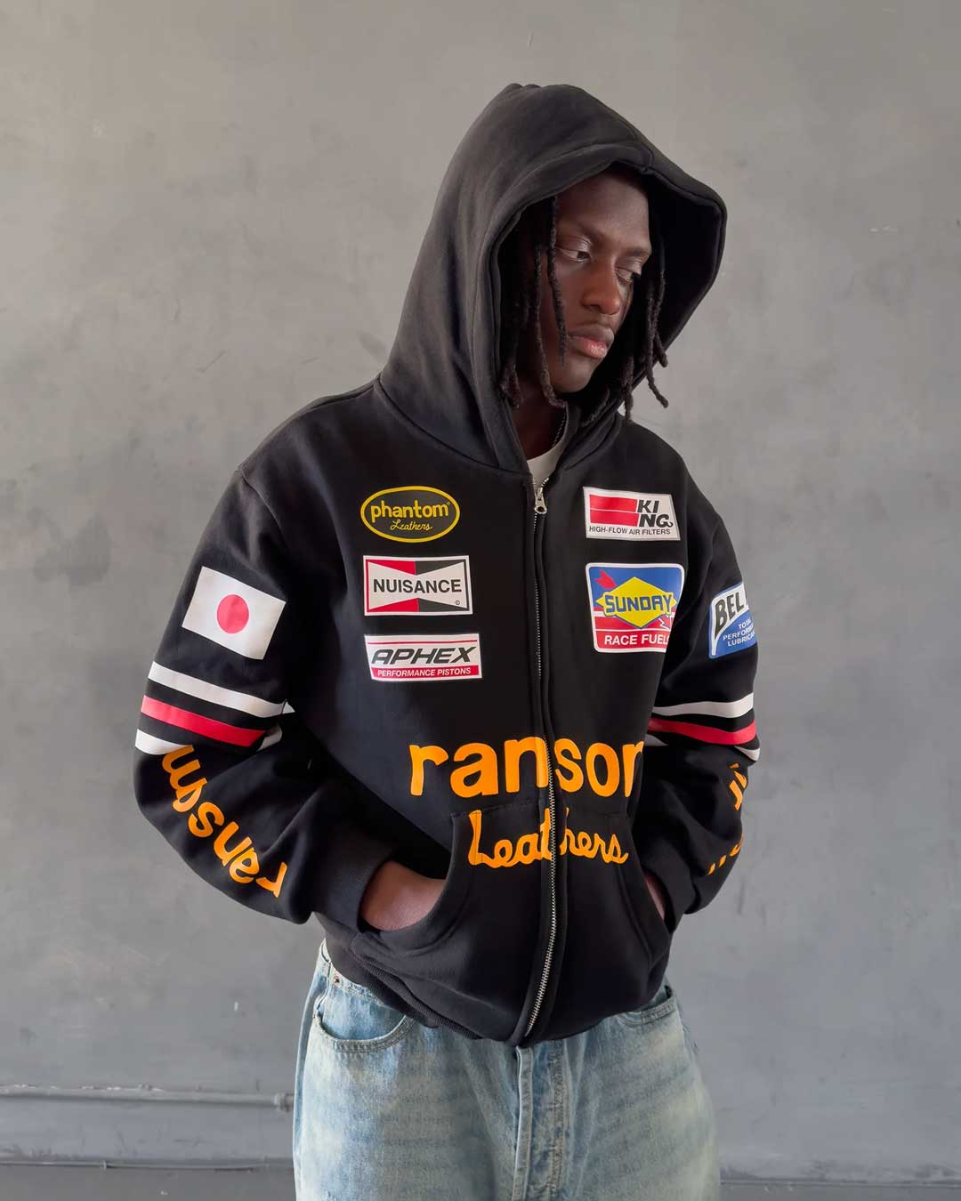 Bravest Studios Ransom Zip Up Hoodie black, worn by a model showing the sleeve ransom lettering, styled view