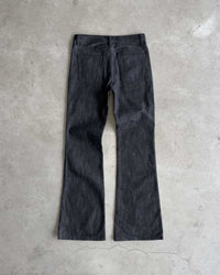 Bravest Studios Raw Flare Denim black, flat-lay back view on concrete showing the flare from the knee
