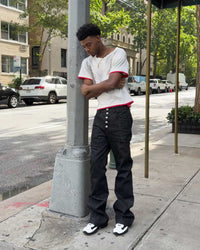 Bravest Studios Raw Flare Denim black, side-on model shot showing the flare and raw hem length