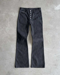 Bravest Studios Raw Flare Denim black, flat-lay front view on concrete showing the full flared silhouette