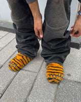 Bravest x Glo Gang Tiger Bear Claw Mule orange with black stripes and chrome claws, close up model