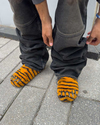 Bravest x Glo Gang Tiger Bear Claw Mule orange with black stripes and chrome claws, close up model