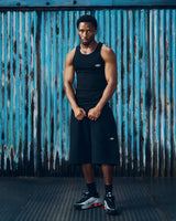 Corteiz HMP Classic Tank Top black, worn by a model with matching black shorts, full-length front view