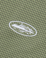 Corteiz HMP Classic Tank Top olive, close-up of the embroidered white Alcatraz Island oval on the waffle knit