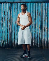 Corteiz HMP Classic Tank Top white, worn by a model with grey shorts, full-length front view