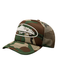 Corteiz Island Puff Print Trucker Hat woodland camo, foam-front mesh-back trucker cap with raised white puff-print Alcatraz Island graphic, three-quarter front view