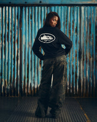 Corteiz OG Island LS Tee black, worn by a model, back view showing the large white Alcatraz Island oval