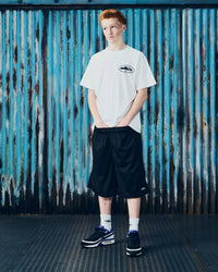 Corteiz OG Island Tee white, worn by a model with black mesh shorts, front view showing the small chest island graphic