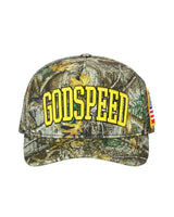 Godspeed Americana Trucker Hat Tree Camo, tree camo trucker cap with raised yellow varsity GODSPEED embroidery and a US flag side tag, front view