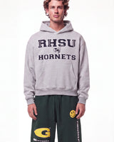 A male model wearing a light gray pullover hoodie with 'RHSU HORNETS' printed in navy blue on the front, paired with dark green sweatpants, against a plain white studio background.
