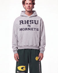 A male model wearing a light gray pullover hoodie with 'RHSU HORNETS' printed in navy blue on the front, paired with dark green sweatpants, against a plain white studio background.