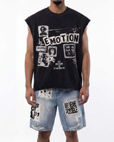 A man wearing a black sleeveless graphic t-shirt with white distressed text and images, paired with light blue denim shorts featuring ripped details and patches.
