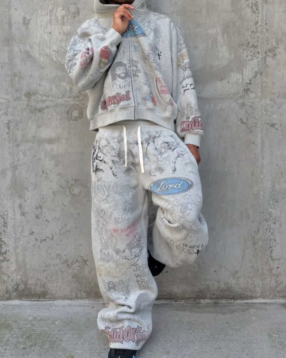 Model wearing Righteous Jesus My Lord grey zip up hoodie with matching sweatpants against a concrete wall