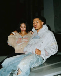 Two models posing in Righteous Jesus My Lord grey zip up hoodie, seated side view