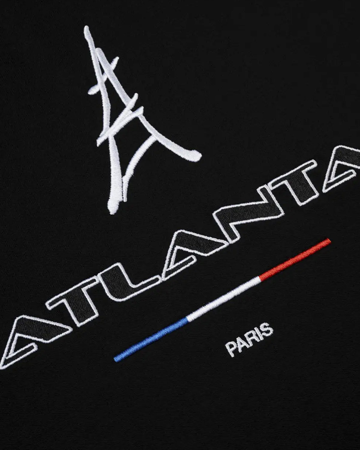 Sp5der Arraignee Tee black, close-up of the Eiffel Tower embroidery, ATLANTA wordmark, tricolour bar and PARIS lettering