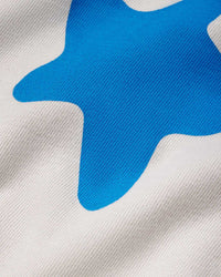 Sp5der Beluga Tee plastic, close-up of the blue puff-print stars on bone grey cotton
