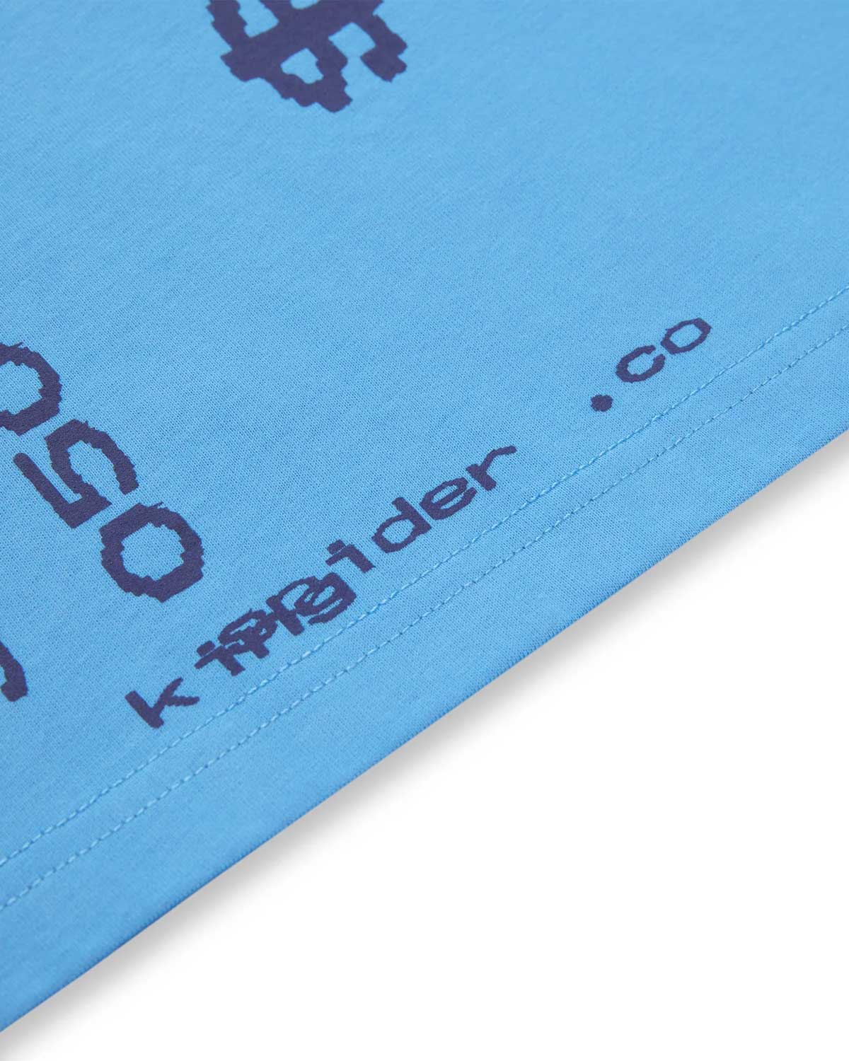 Sp5der Commerce Tee dusty blue, close-up of the hem print and logo tag
