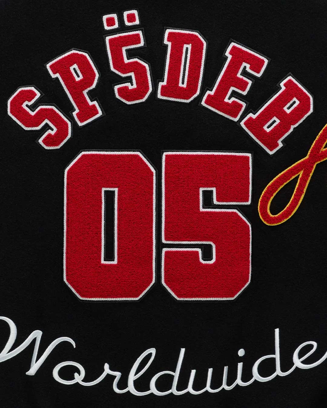 Sp5der District Cuntry Varsity Jacket black, close-up of the red chenille SP5DER 05 and Worldwide script on the back