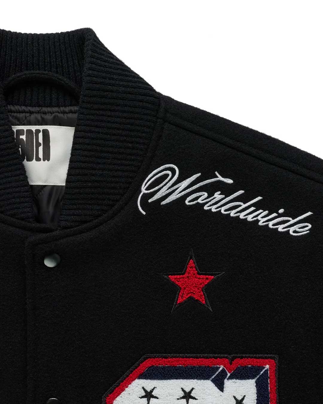 Sp5der District Cuntry Varsity Jacket black, close-up of the embroidered Worldwide script and red star at the shoulder