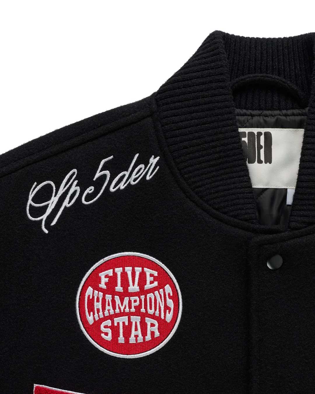Sp5der District Cuntry Varsity Jacket black, close-up of the Sp5der script and Five Champions Star patch