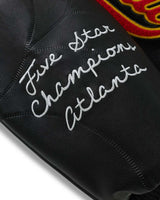 Sp5der District Cuntry Varsity Jacket black, close-up of the Five Star Champions Atlanta embroidered script on the sleeve