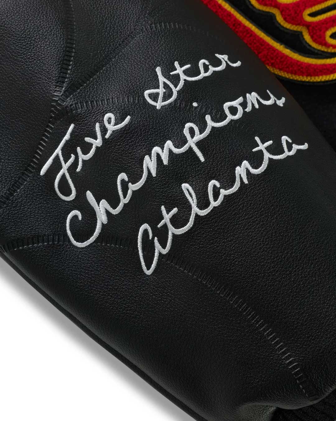 Sp5der District Cuntry Varsity Jacket black, close-up of the Five Star Champions Atlanta embroidered script on the sleeve