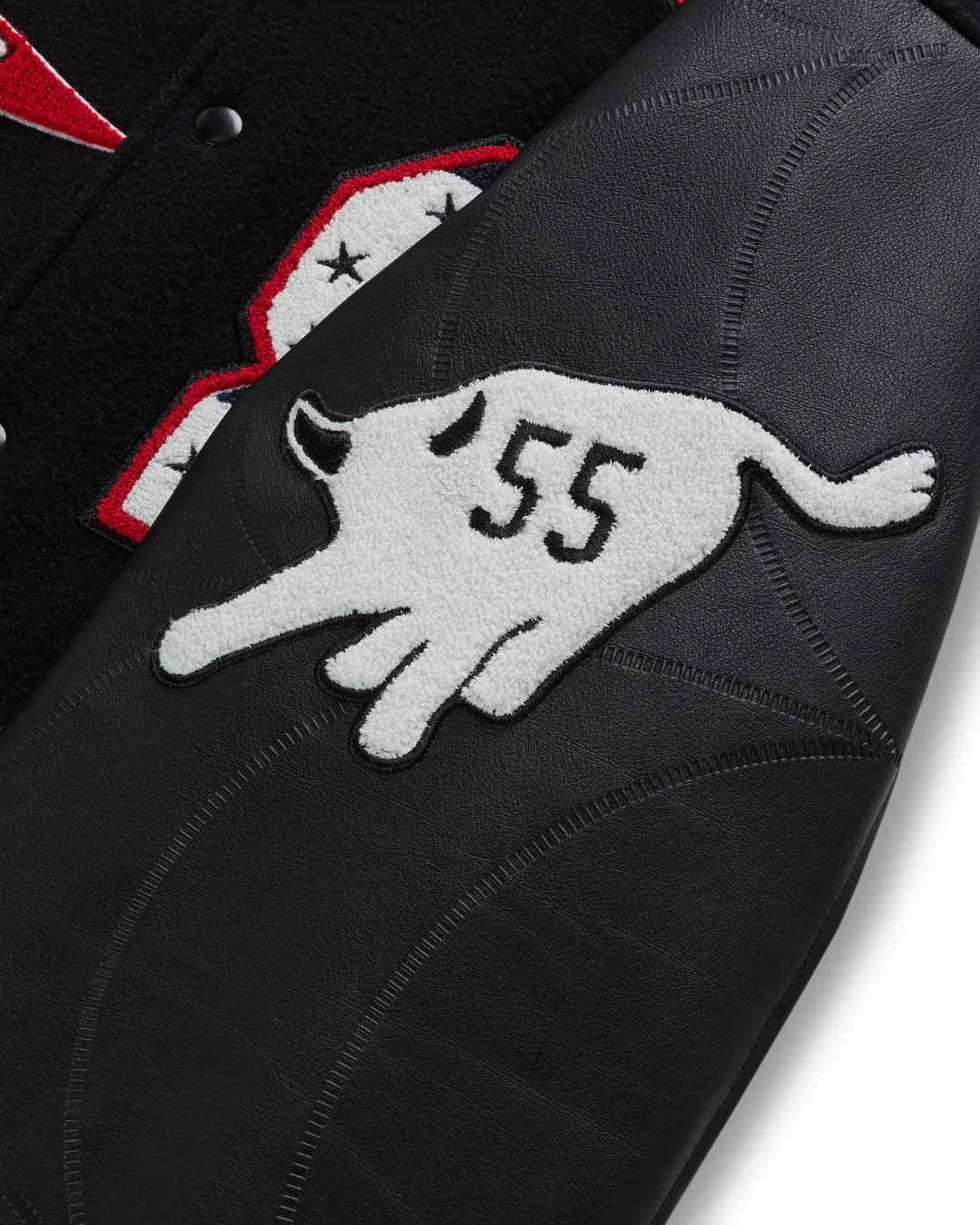 Sp5der District Cuntry Varsity Jacket black, close-up of the white 55 chenille patch on the sleeve