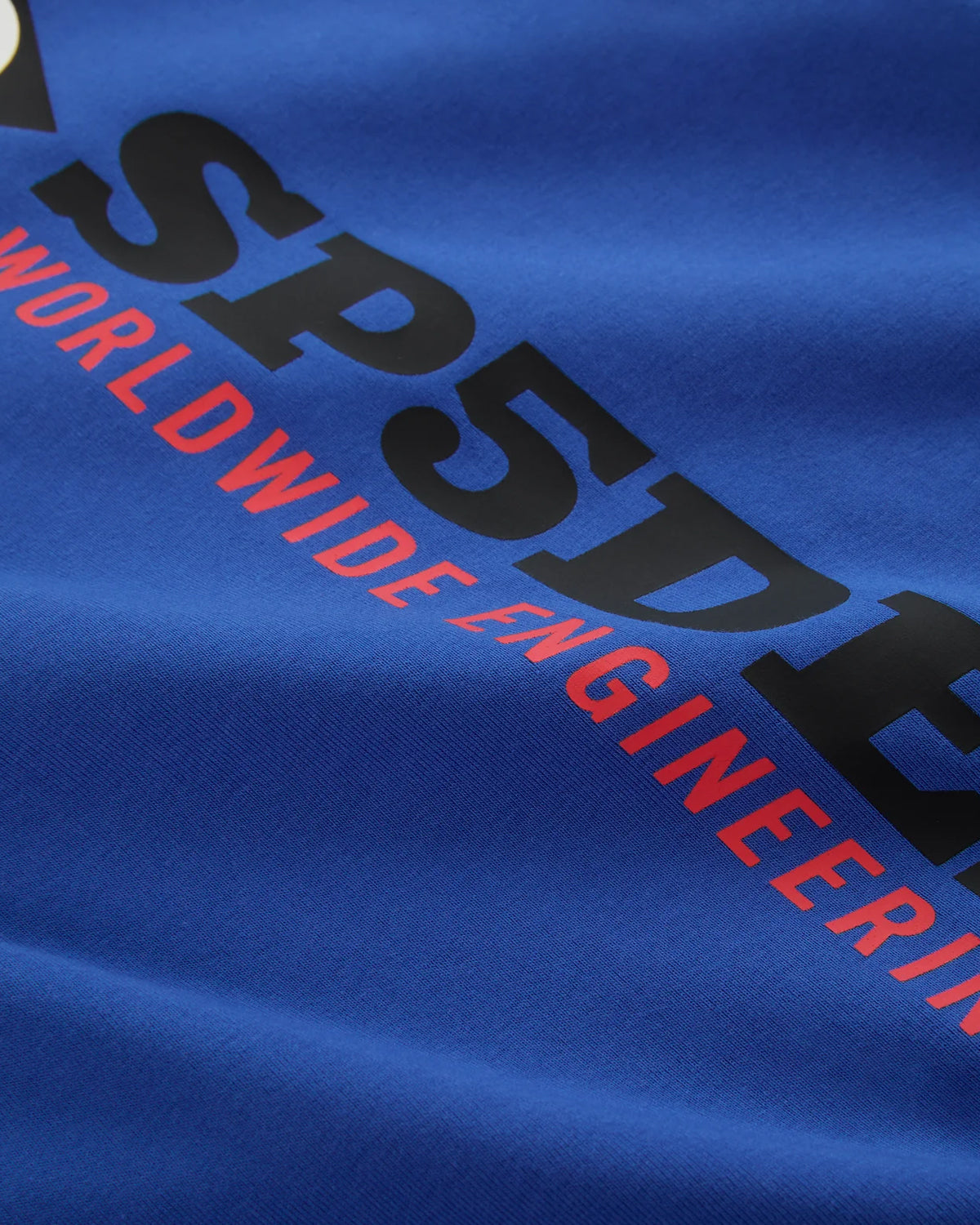 Sp5der Engineer Tee blue, angled close-up of the printed chest wordmark on the jersey
