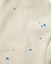 Sp5der Heavy Web Hoodie foam cream, close-up of the tonal web print with blue star accents