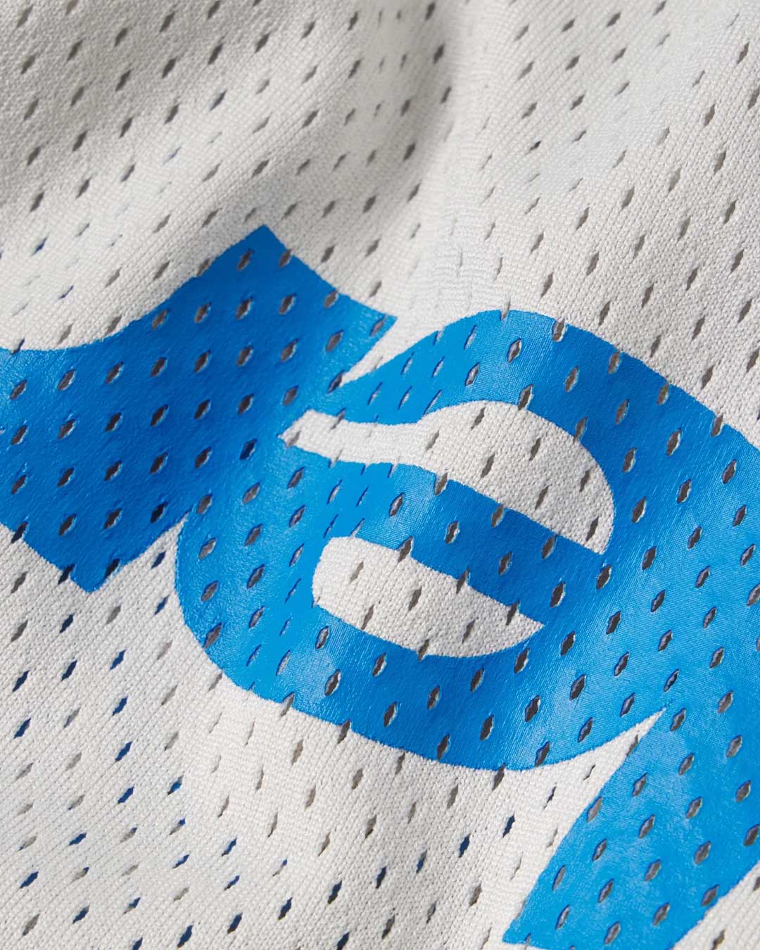 Sp5der Mesh Double Layer Shorts plastic, macro close-up of the blue sp5der wordmark printed on perforated grey mesh
