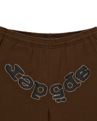 Sp5der OG Web Rhinestone Sweatpants brown, close-up of the full arched rhinestone wordmark below the elastic waistband