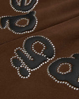 Sp5der OG Web Rhinestone Sweatpants brown, close-up of the black lettering outlined in silver rhinestones