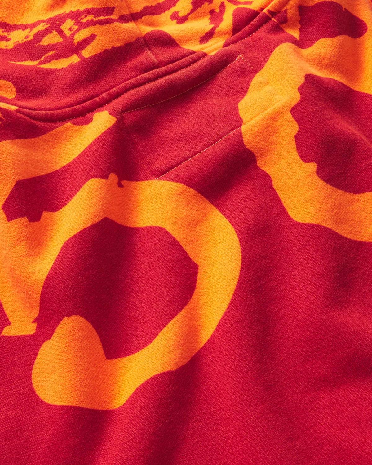 Sp5der Overprint Zip Up Hoodie tangerine orange, close-up of the orange Sp5der print on the red back panel