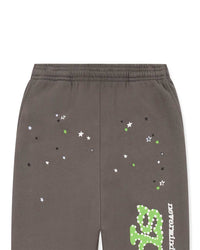 Sp5der P*nk V1 Sweatpants slate grey, close-up of the green, white and black star scatter above the leg logo