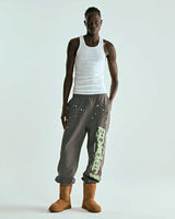 Sp5der P*nk V1 Sweatpants slate grey, worn on model with a white tank top and boots, full front view