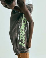 Sp5der P*nk V1 Sweatpants slate grey, worn on model, angled close-up of the leg graphic and star print