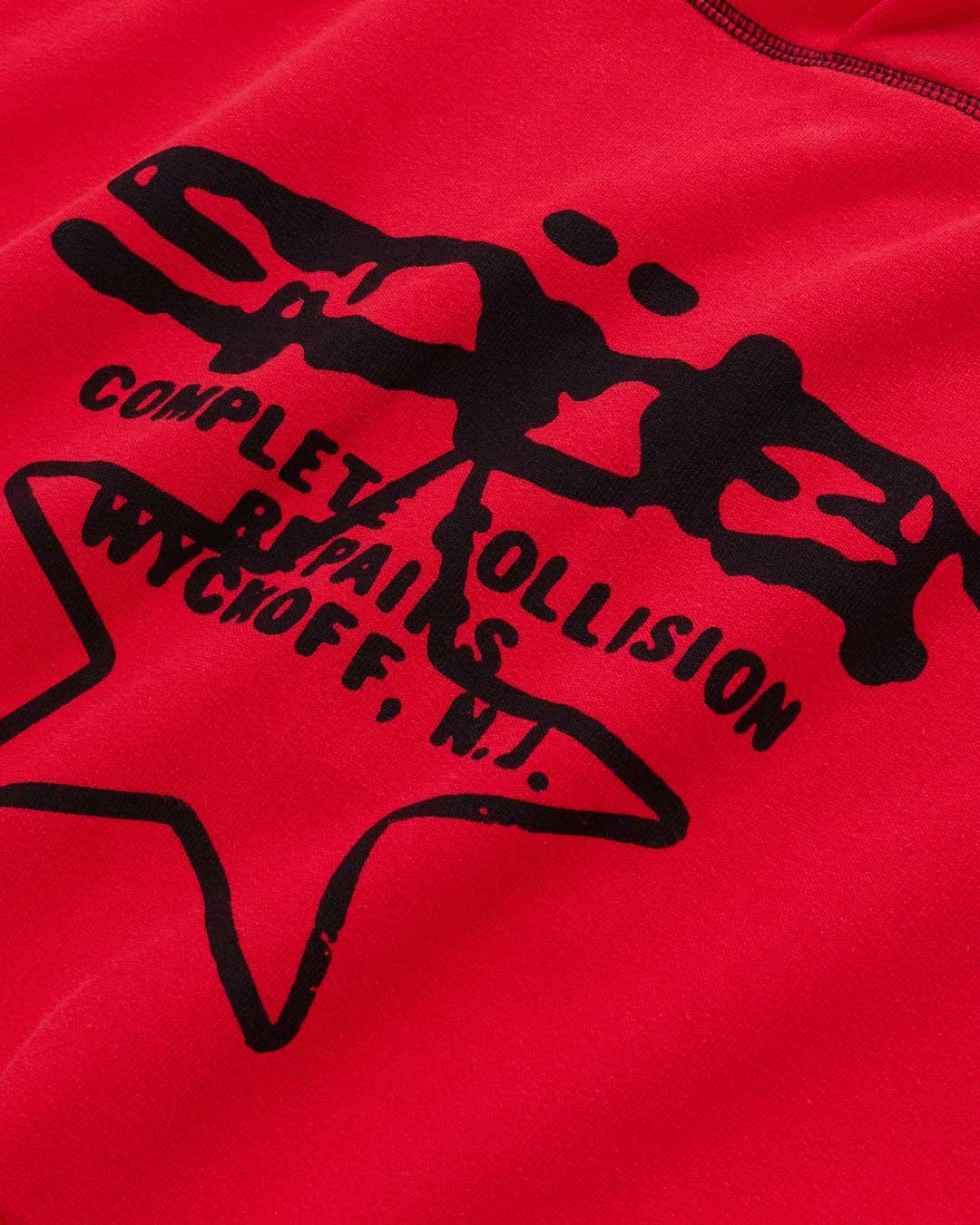 Sp5der Solar Collision Hoodie red, close-up of the black star print and lettering