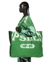 Sp5der Sp5 Jersey Tote Bag kelly green held at the shoulder by a model, front lettering and oval badge visible