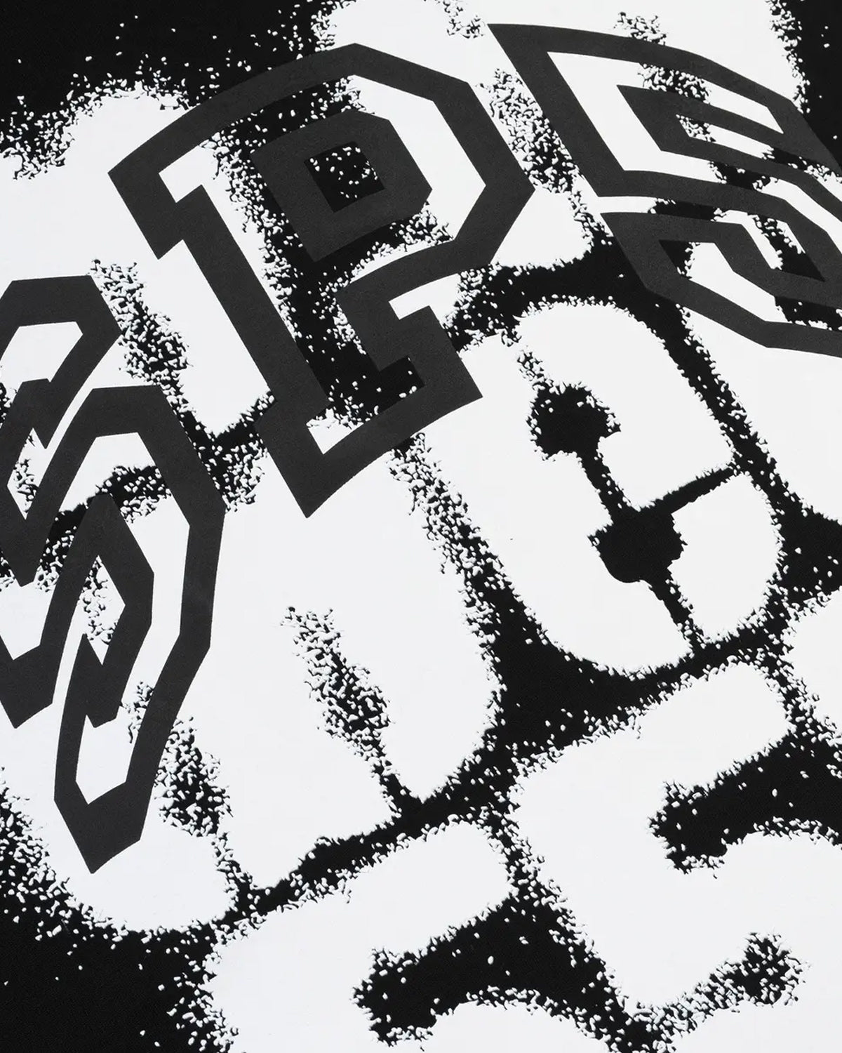 Sp5der Sp555 Spray Tee black, close-up of the white spray-paint lettering and black outline type