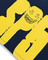 Yellow and navy glove with a stylized face design on a dark background