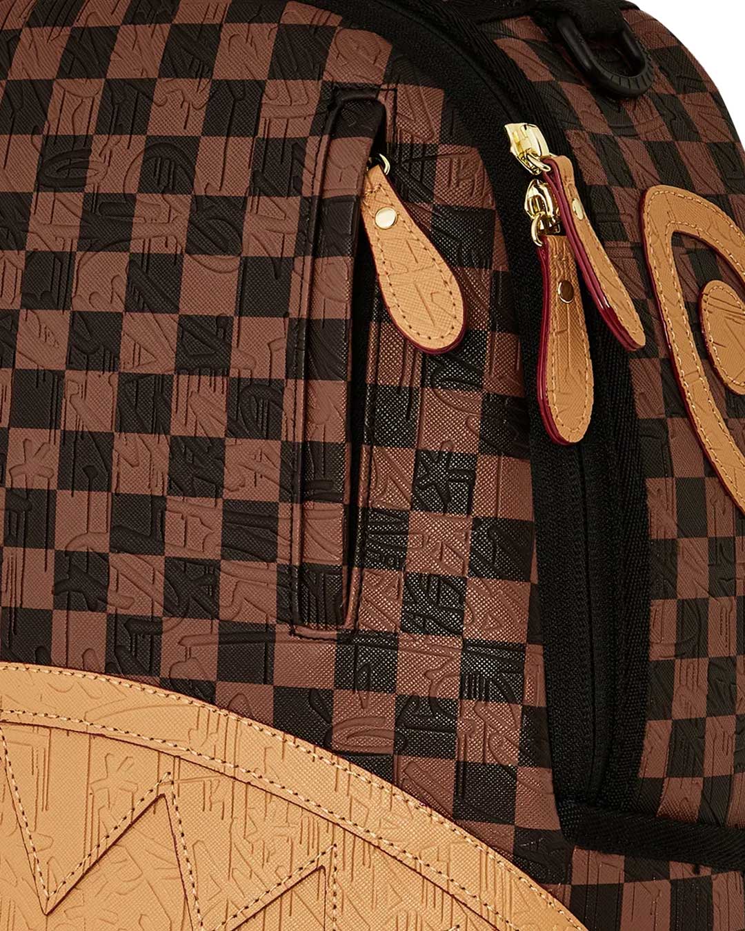 Sprayground Chess Not Checkers Backpack, close-up of the tan embossed shark teeth