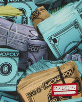 Sprayground Monopoly Money Stacks Backpack, close-up of the Monopoly and Sprayground logo tab
