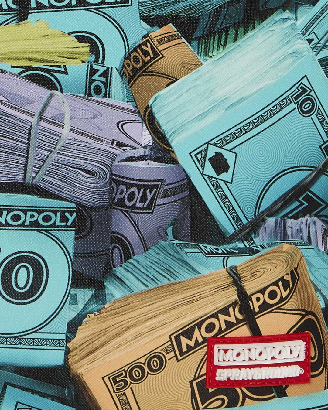 Sprayground Monopoly Money Stacks Backpack, close-up of the Monopoly and Sprayground logo tab