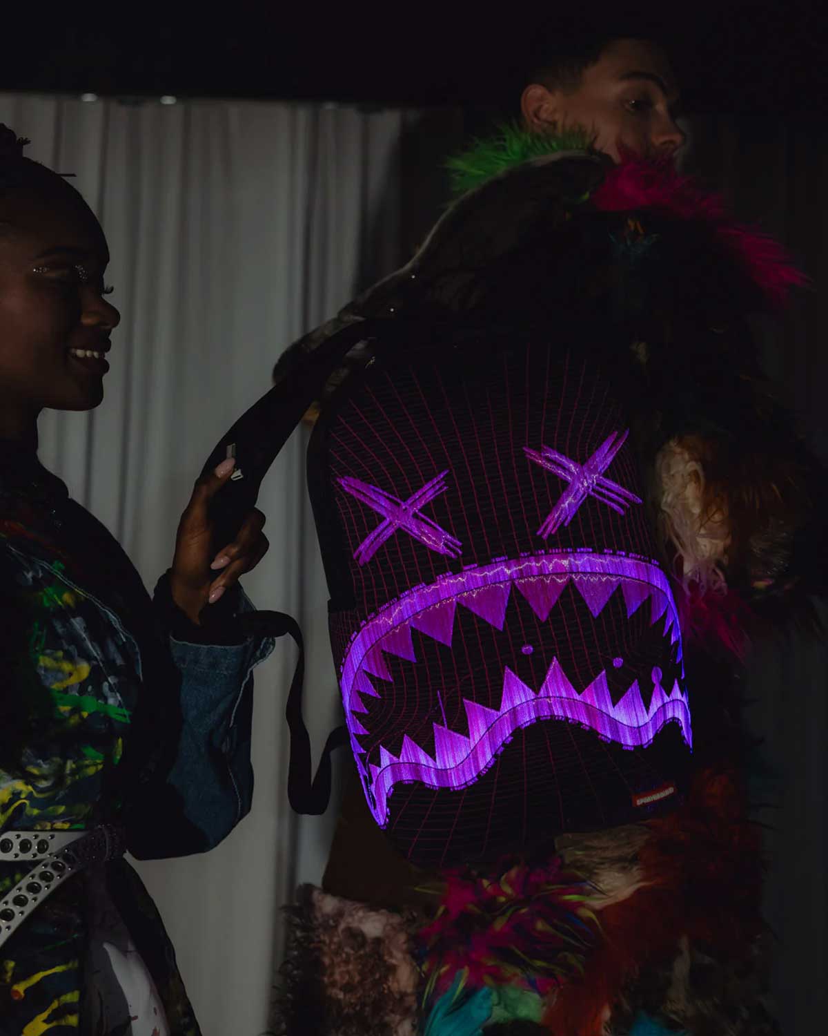 Sprayground Party Shark Fiber Optics Backpack, glow-in-the-dark view with the fiber-optic shark face lit