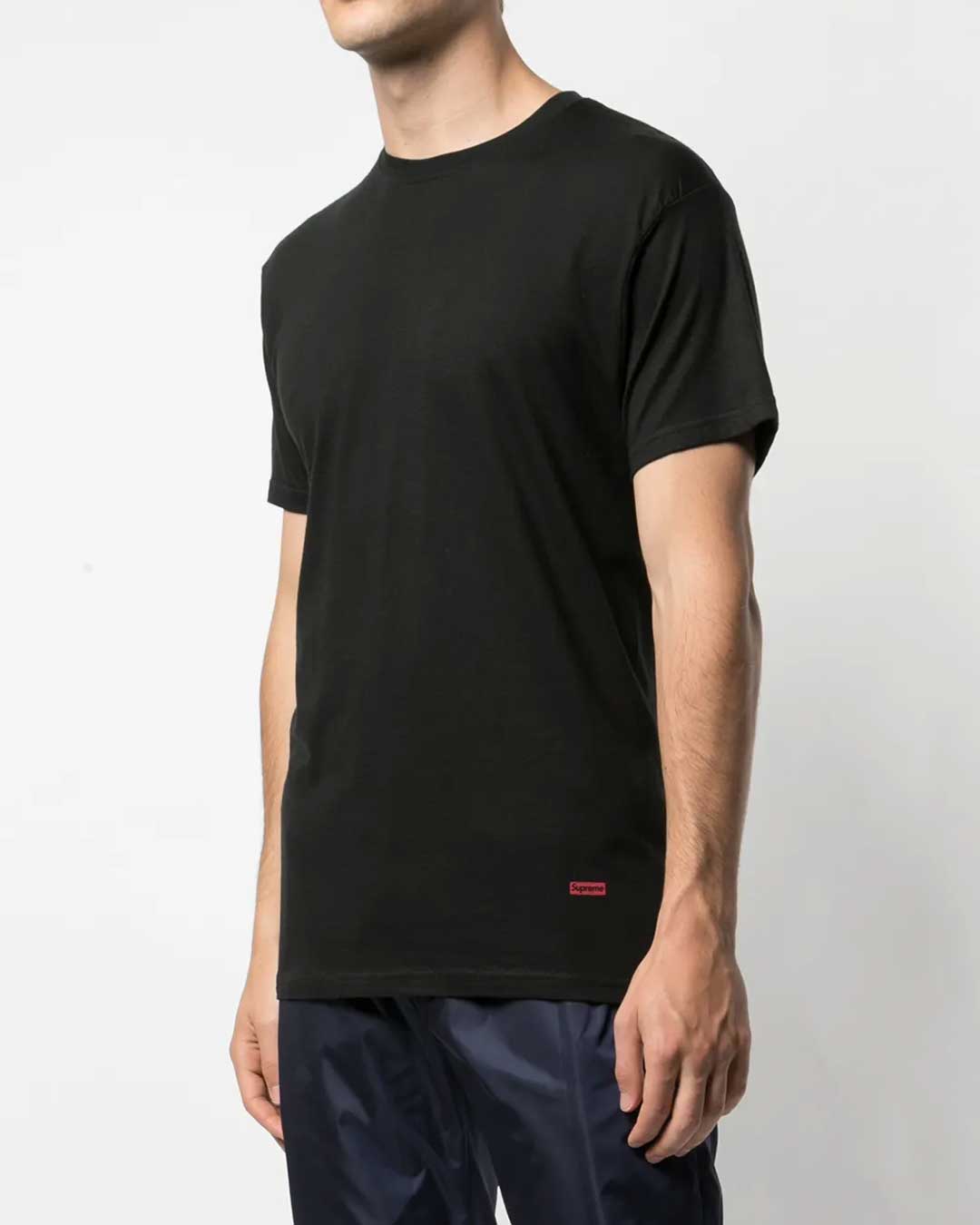 Supreme x Hanes Tagless Tee black 3 pack, worn on model showing the red Supreme hem tab