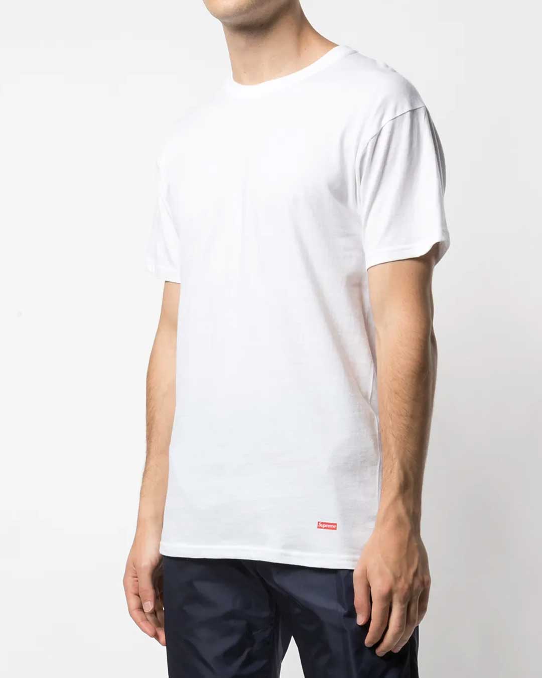 Supreme x Hanes Tagless Tee white 3 pack, worn on model showing the red Supreme hem tab