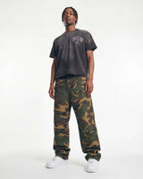 Model wearing Boredom Kills Double Pants camo with a washed black graphic tee, full front view