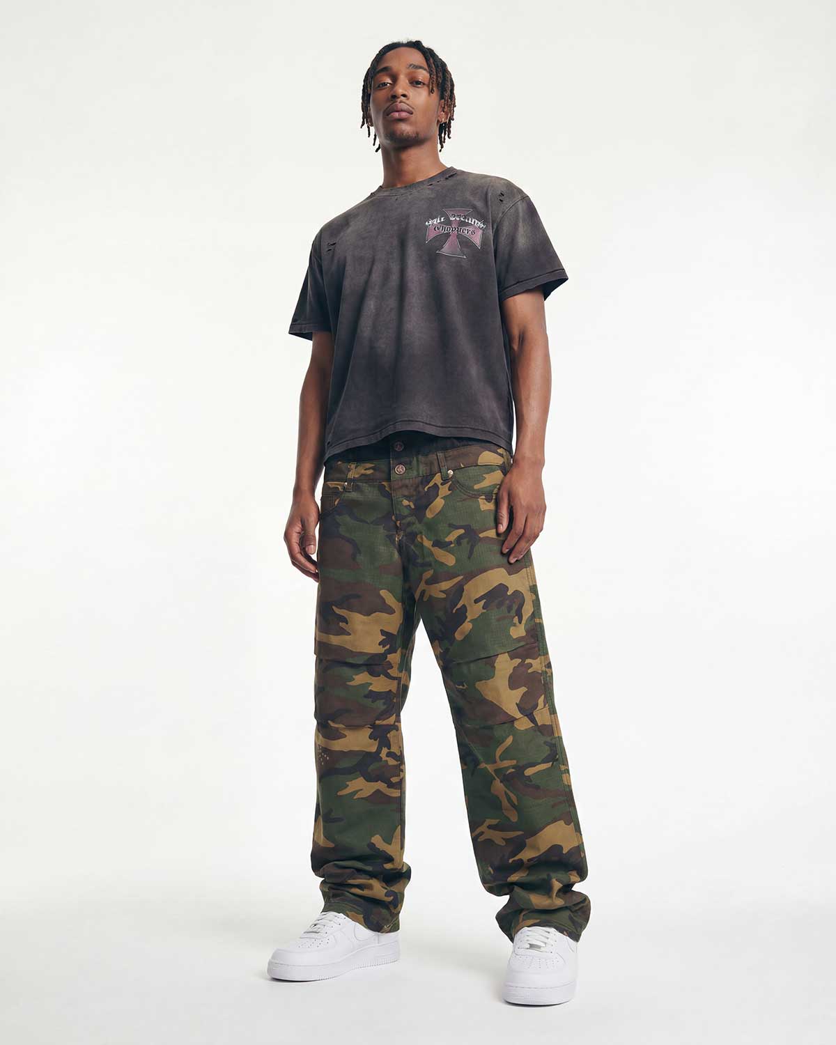 Model wearing Boredom Kills Double Pants camo with a washed black graphic tee, full front view