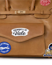 Vale Forever Lucky Charms Bag tan, close-up of the Property of Vale flap-pocket patch and Valley Dreams Forever roundel